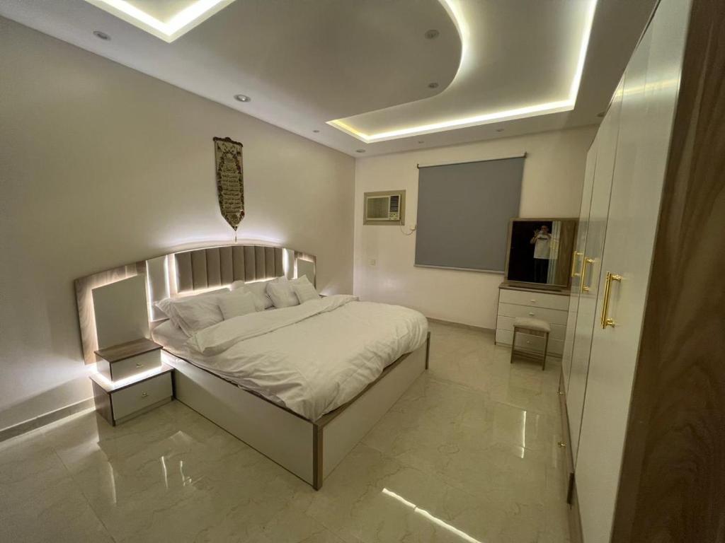 um quarto com uma cama e uma televisão em الوسام شقه فندقيه 3 غرف نوم وصاله Al Wissam contains 3 bedrooms and a living room em Taif