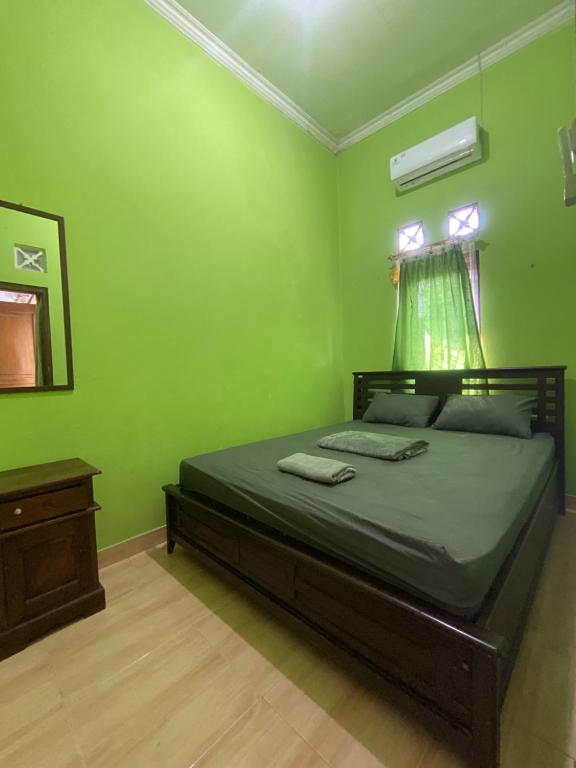 um quarto com uma cama com uma parede verde em Malaya em Ngabean