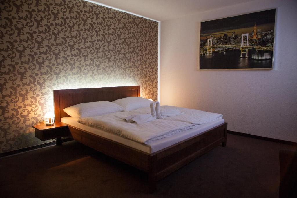 a bedroom with a bed and a picture on the wall at Penzión Arizona in Zlaté Moravce