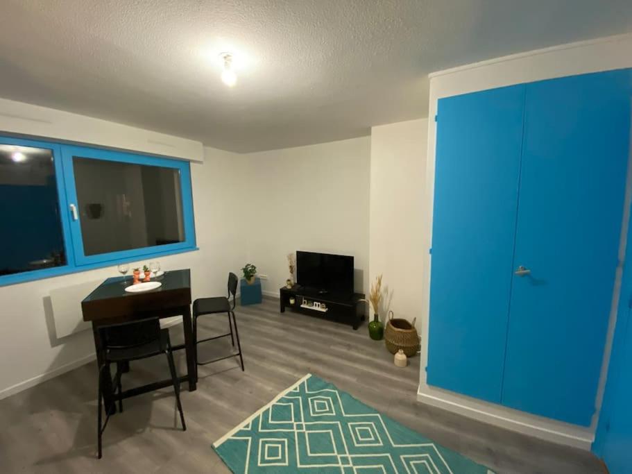 sala de estar con mesa y puerta azul en Krutenau Lifestyle en Estrasburgo