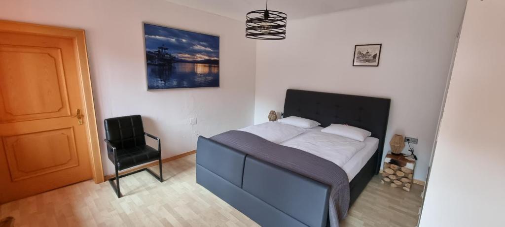 1 dormitorio con 1 cama, 1 silla y 1 puerta en Landhaus Nikki, en Gmünd in Kärnten