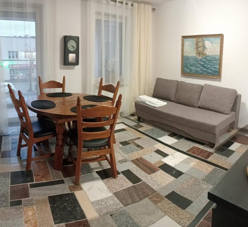 a living room with a table and a couch at Apartament Włoski Styl in Gniezno