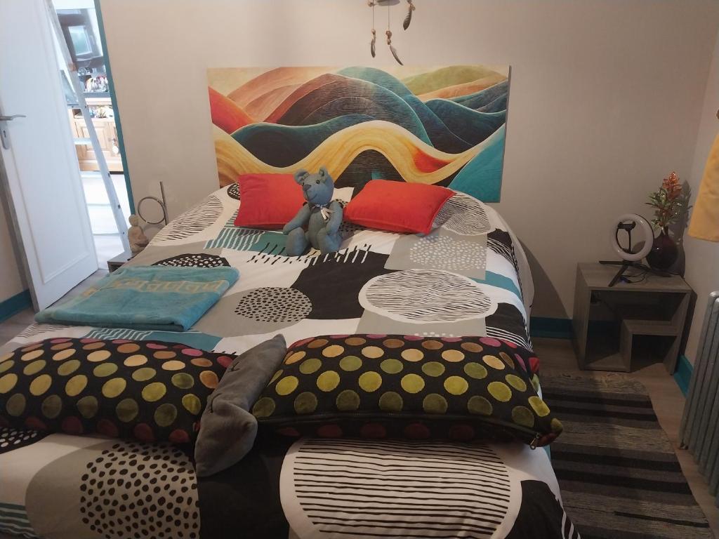 a bed with a teddy bear sitting on top of it at Une chambre presque en ville in Quimper
