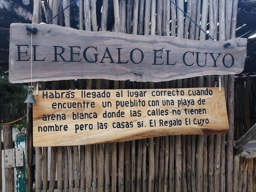 Ein Schild, auf dem El regalo el cijoco auf einem Zaun steht. in der Unterkunft El Regalo El Cuyo in El Cuyo