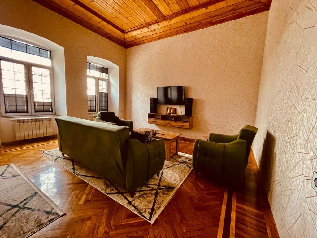 een woonkamer met een bank en stoelen en een tv bij OZAN LUXHOUSE in Ganja