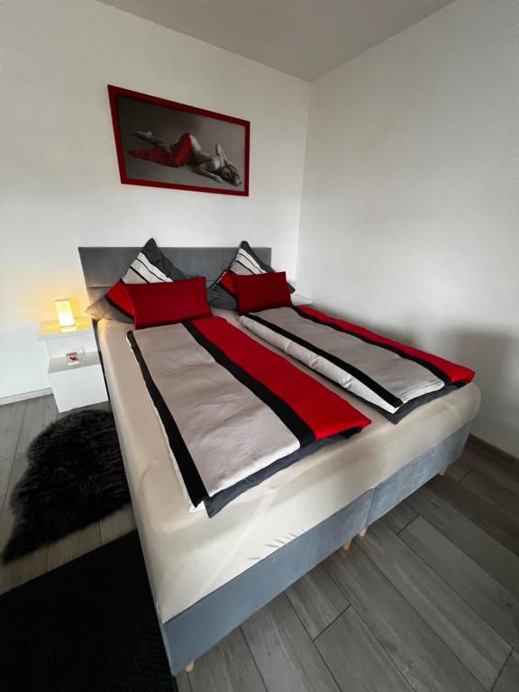 a bedroom with a bed with red and black pillows at Modern Apartment in Augsburg