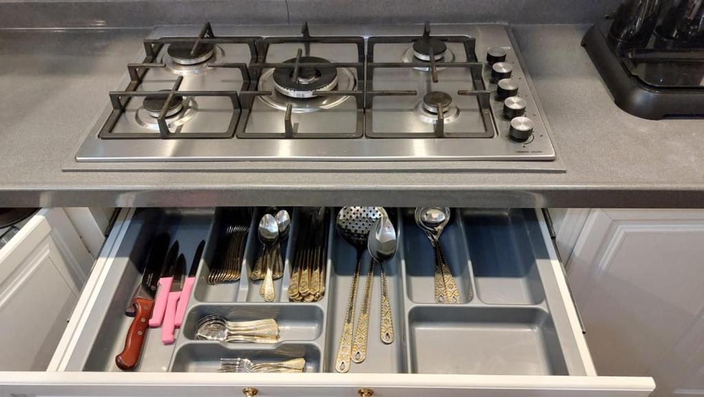 a stove top oven with utensils in a kitchen at شقق جدة دستنيشن in Jeddah