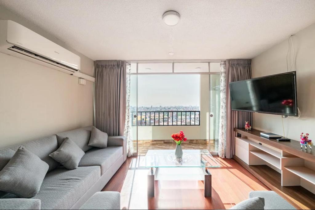 a living room with a couch and a television at Apartamentos Estela en Alameda colonial - 5km Aeropuerto Jorge Chávez in Lima