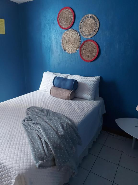 グアテマラシティにあるCasa familiar La Arboledaの青いベッドルーム(壁にバスケット付きのベッド付)