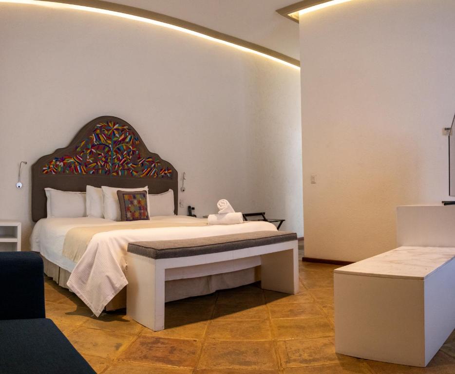 a bedroom with a bed and a bench in a room at Casa Pepe in Puebla