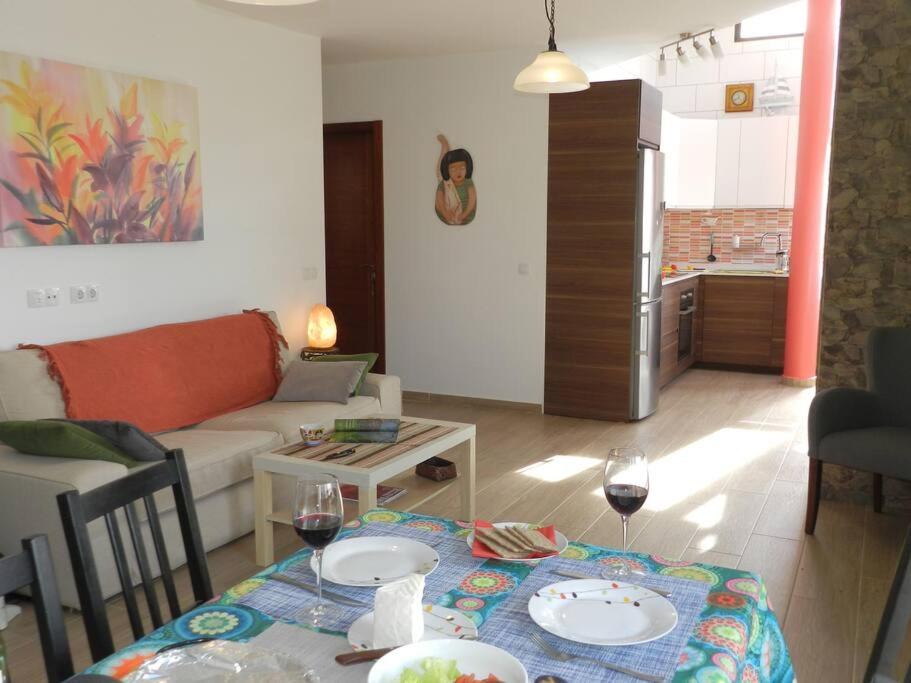 a living room with a couch and a table with glasses of wine at Vivienda La Majorera, tranquila , luminosa, acogedora in Puerto del Rosario