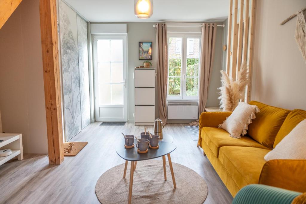un salon avec un canapé jaune et une table dans l'établissement La Musardière, charmante maison à 200m du Quai, à Saint-Valery-sur-Somme