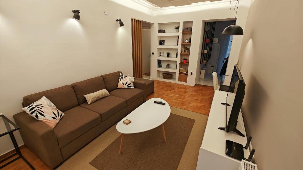 uma sala de estar com um sofá e uma mesa de centro em Think Home, exploring the center of Thessaloniki em Tessalónica