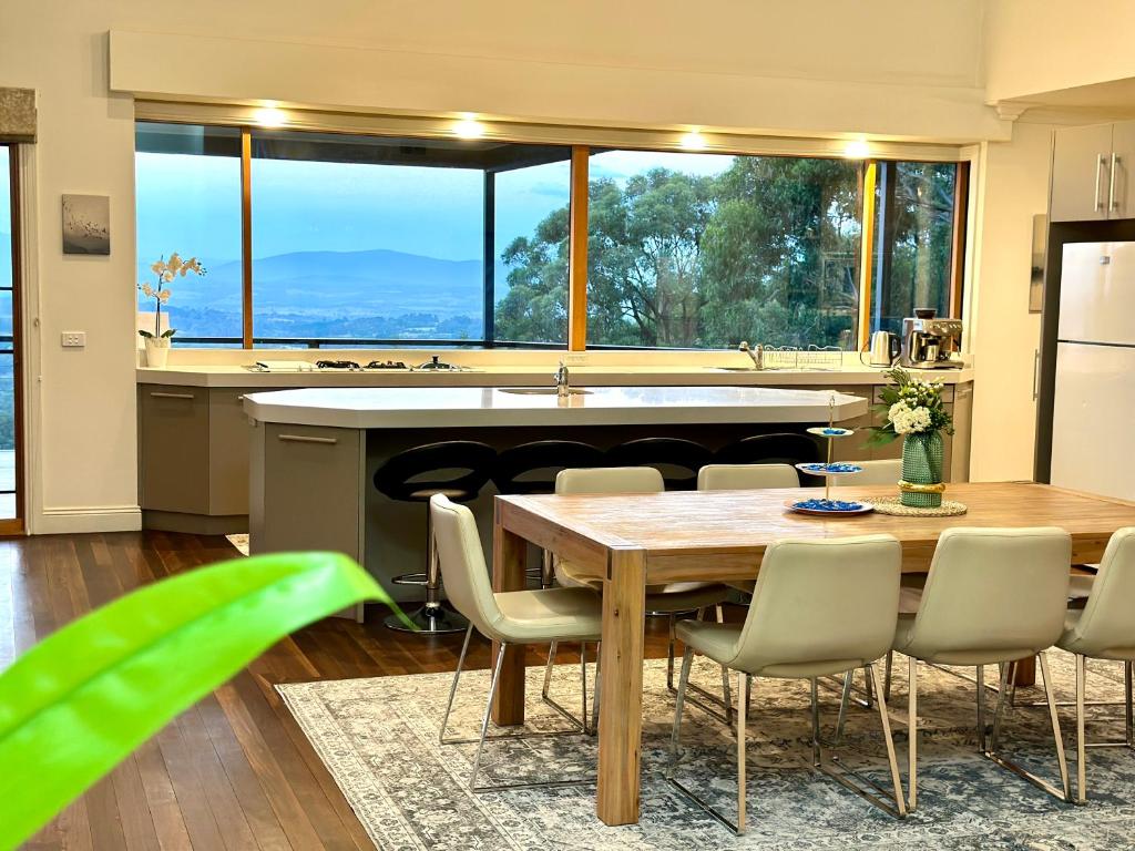 奧林達的住宿－Olinda Cascade Waterfall Mountain View Retreat，一个带桌椅和大窗户的厨房