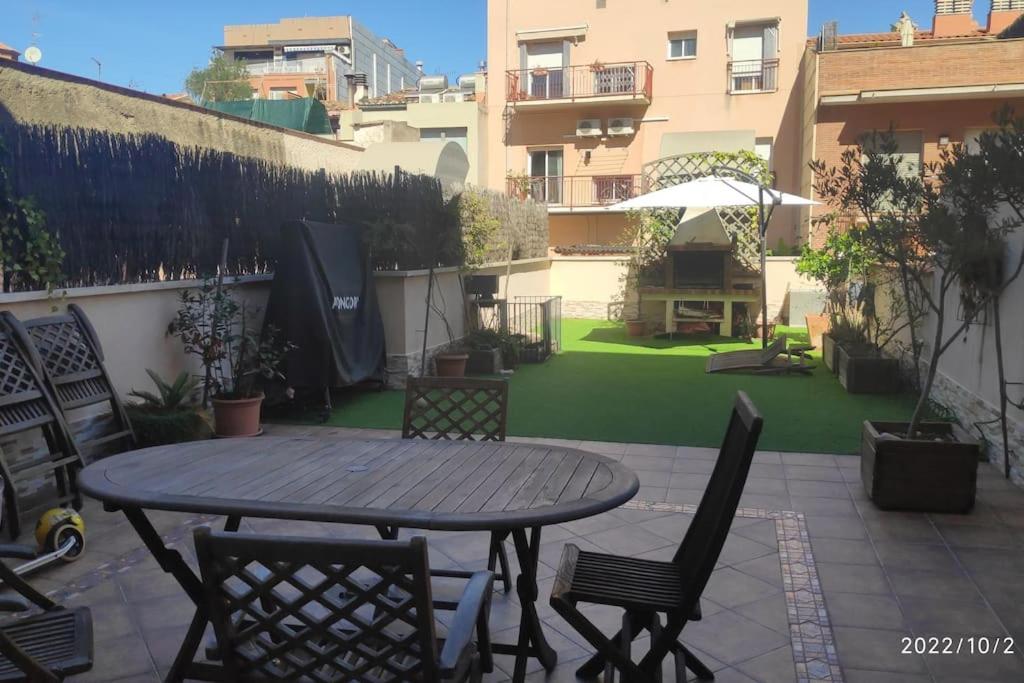 einen Tisch und Stühle auf einer Terrasse mit Garten in der Unterkunft Precioso apartamento con magnífico patio. in Sant Feliu de Llobregat