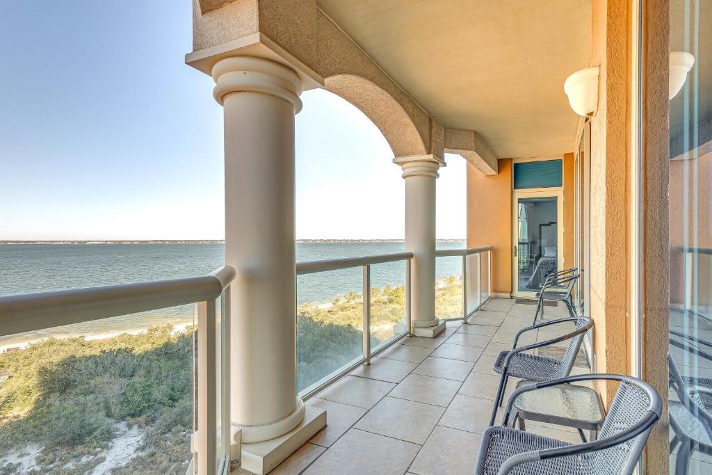 Un balcón con sillas y vistas al océano. en Florida Resort Condo Walk to Pensacola Beach!, en Gulf Breeze