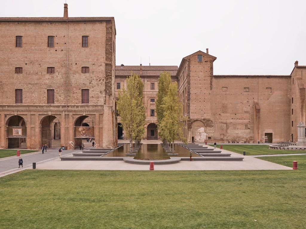 einen Innenhof vor einem großen Backsteingebäude in der Unterkunft Luxury 1 al Duomo di Parma in Parma