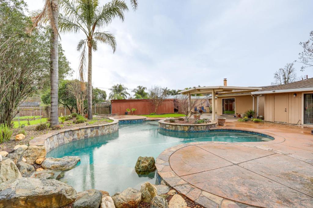 a swimming pool in a yard with palm trees at Citrus Heights Home with Private Pool and Patio! in Roseville