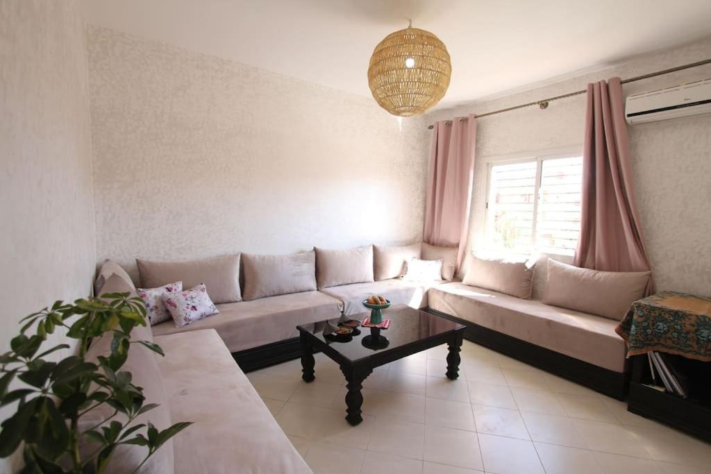 uma sala de estar com um sofá e uma mesa em appartement confort calme propre em Marrakech