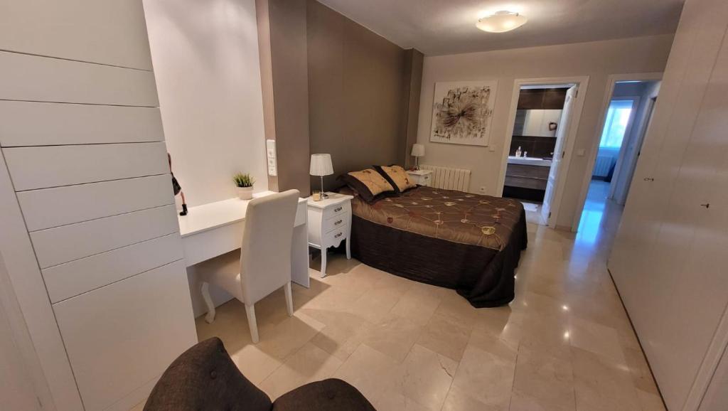 1 dormitorio con cama, escritorio y escritorio en Apartamentos Oasis, en Albir