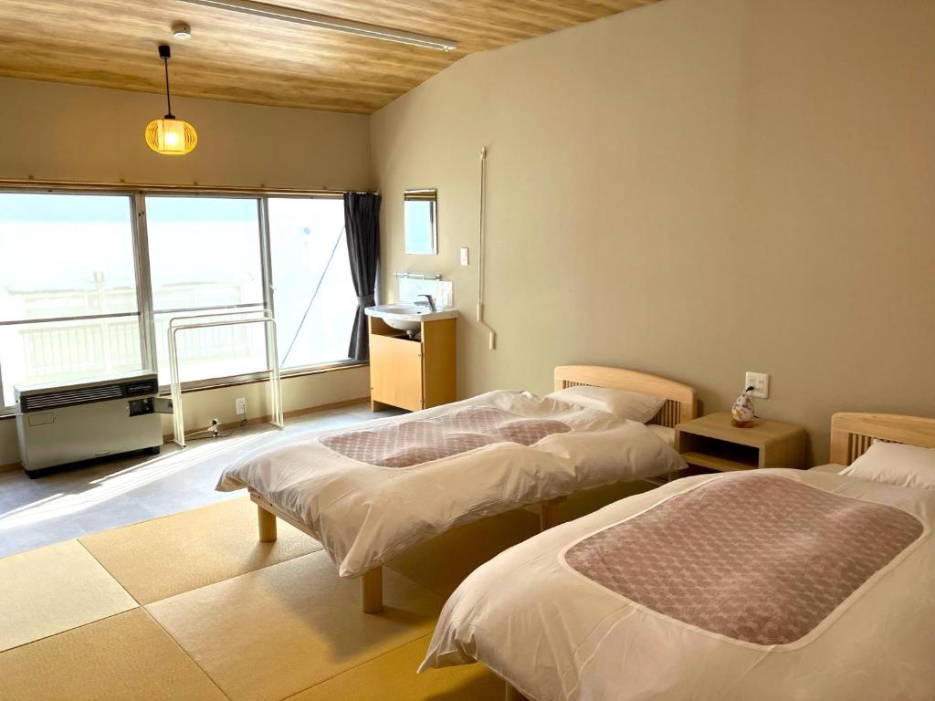 Postel nebo postele na pokoji v ubytování Takasagoya Ryokan