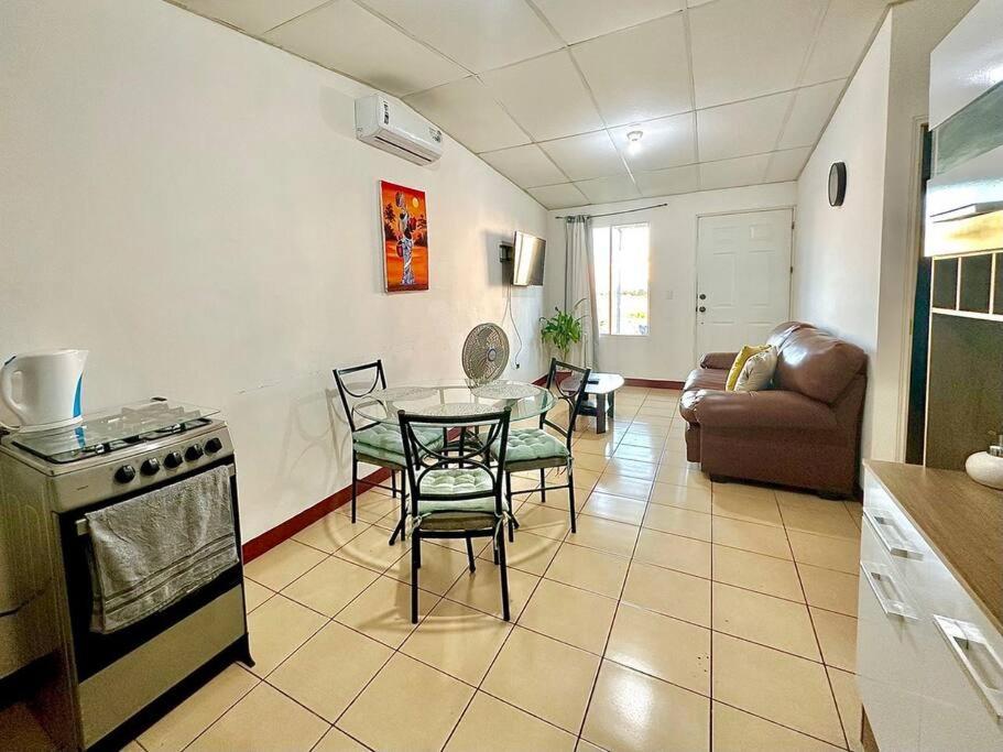 een keuken en een woonkamer met een tafel en stoelen bij Hidden Gem in Managua