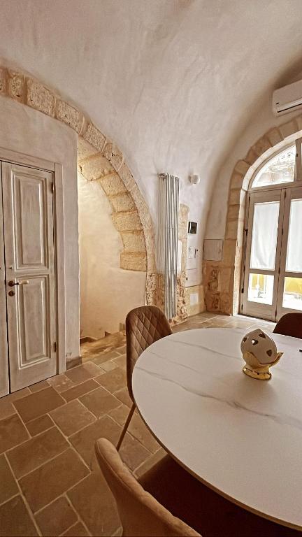 a dining room with a table and chairs in a room at Arquati Suite Luxury Apartment in Ostuni