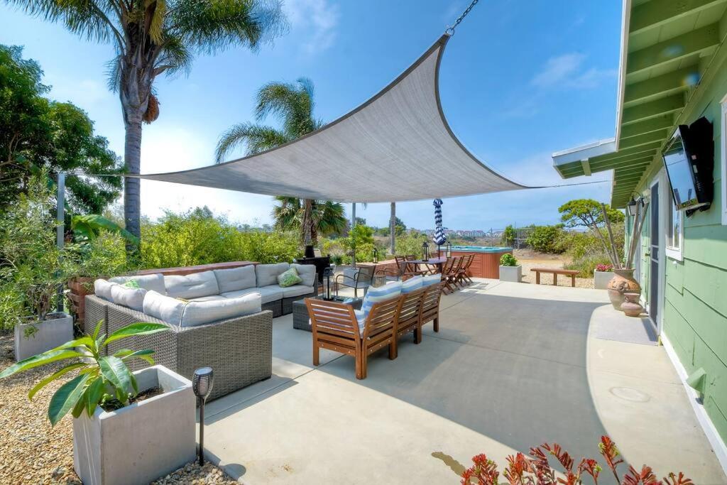 a patio with a couch and a hammock on a house at Ocean View Spa Retreat, Hot Tub, Sauna, Close to the beach, 9 sleeps in Oceanside