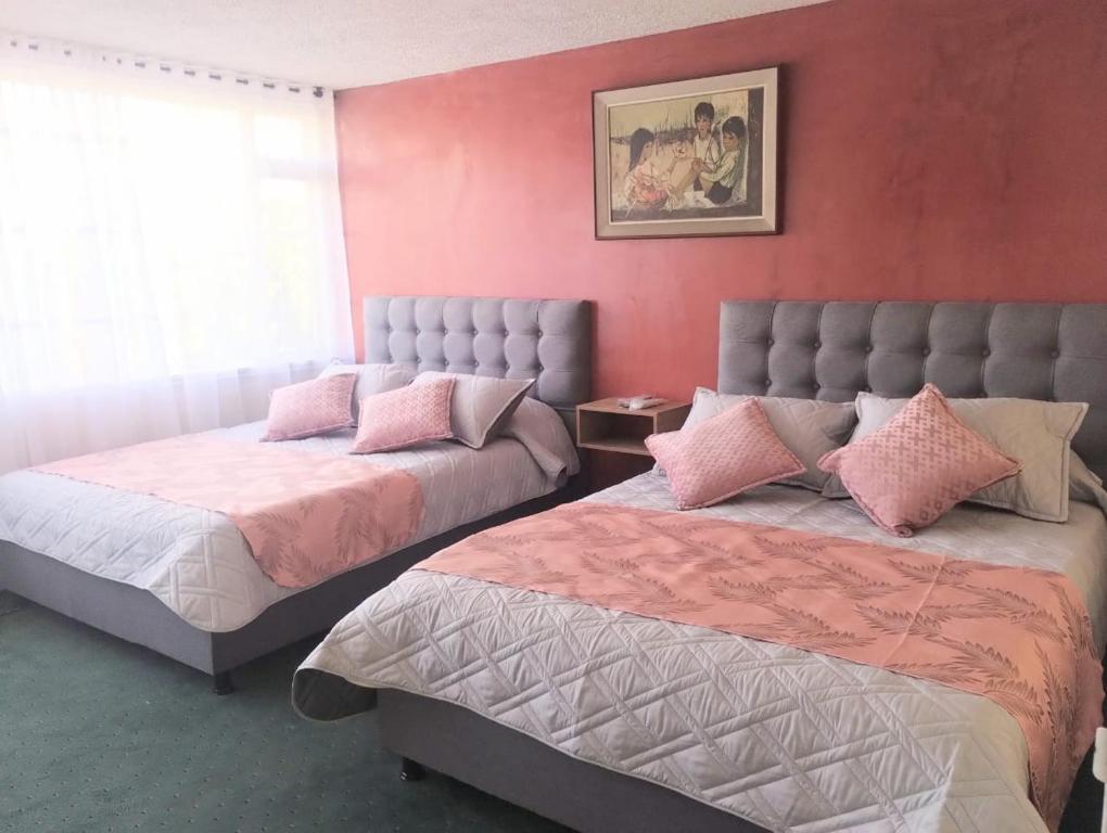 duas camas sentadas uma ao lado da outra num quarto em Innovar Casa Hostal em Bogotá