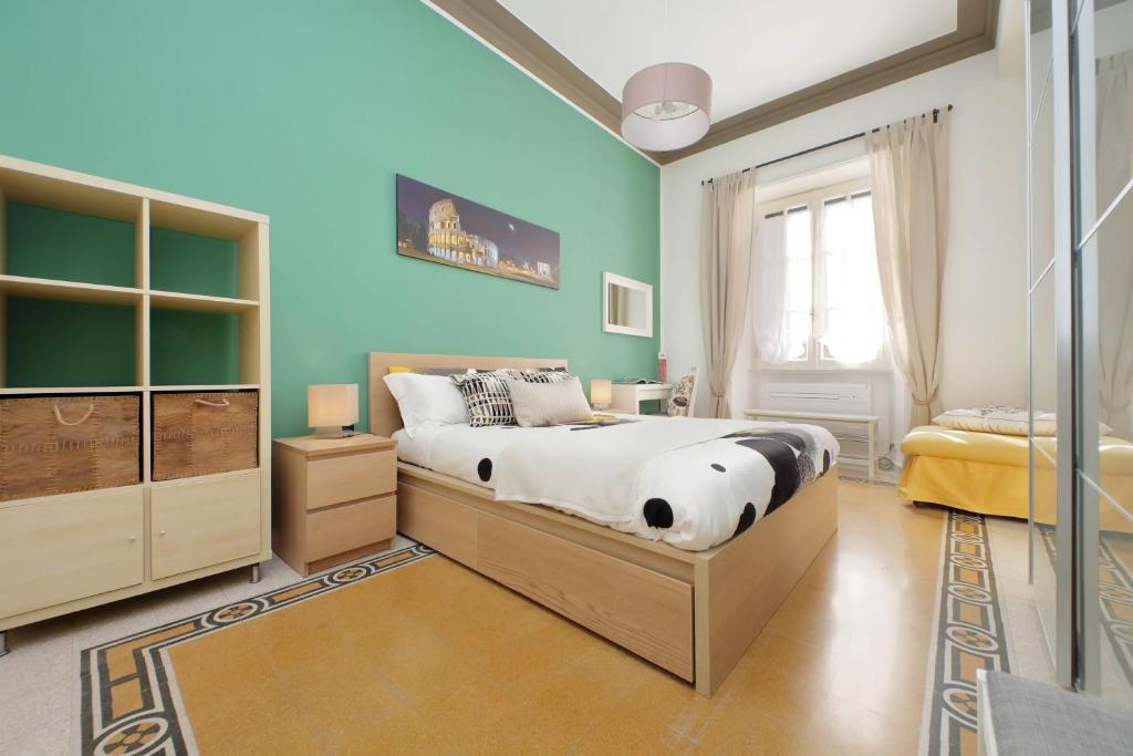 una camera da letto con un letto e una parete blu di CASA GIULIANA - 3BR 2BATH, 2nd floor of historic mansion with lift and doorman, comfortable, chic, family friendly, 600 meters from Vatican & Ottaviano metro, quietest area of P R A T I wealthy, secure, accessible district - Warm guest care in 4 languages a Roma
