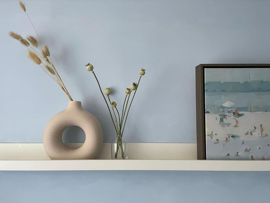 a white shelf with a vase and a picture at Peaceful centrally located, 2 Bedroom Bungalow. in Camborne