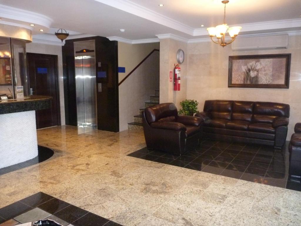 a lobby with a leather couch and a bar at Residencial El Amanecer in Panama City