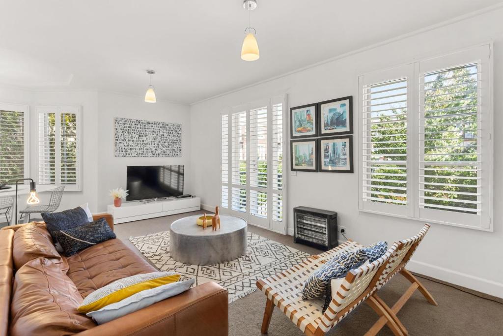 a living room with a couch and a coffee table at Boutique Stays - Wellington Mews in Melbourne