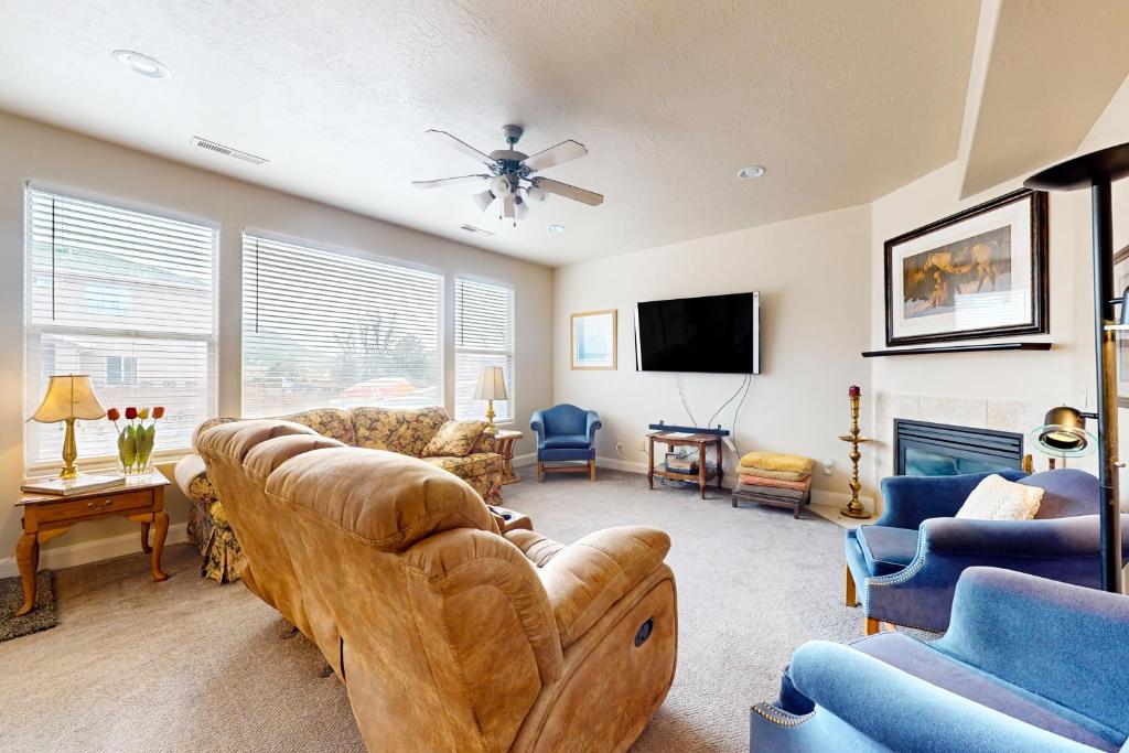 a living room with a couch and chairs and a tv at Cedar City Sanctuary in Cedar City