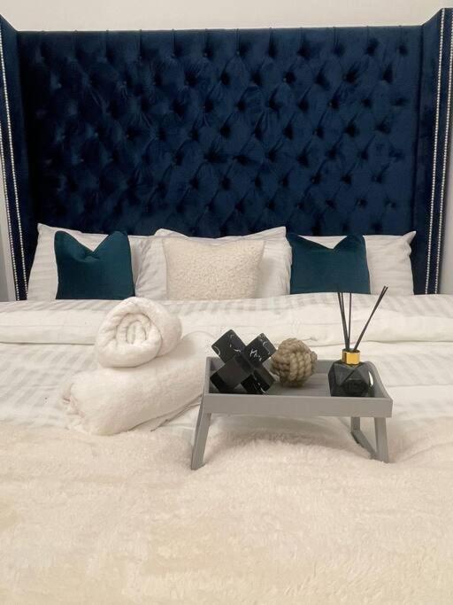 a bedroom with a bed with a blue headboard at Luxury SuperKingsize Bed in London in London