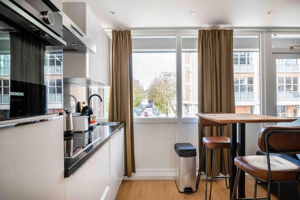 een keuken met een aanrecht, een tafel en een raam bij Apartment Heart of Rotterdam in Rotterdam