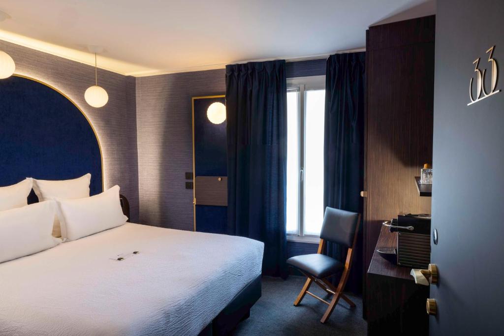 a bedroom with a bed and a desk and a chair at Best Western Bretagne Montparnasse in Paris