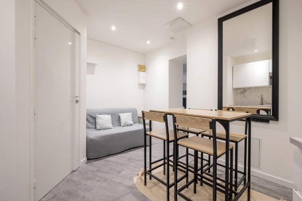un salon avec une table et un canapé dans l'établissement Appartement des Colombes - Welkeys, à Courbevoie