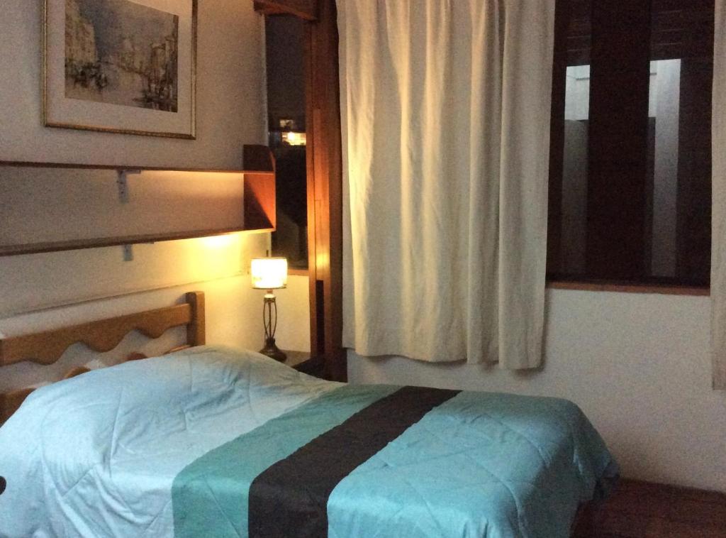 una camera con letto, finestra e lampada di Departamento Estudio a Lima
