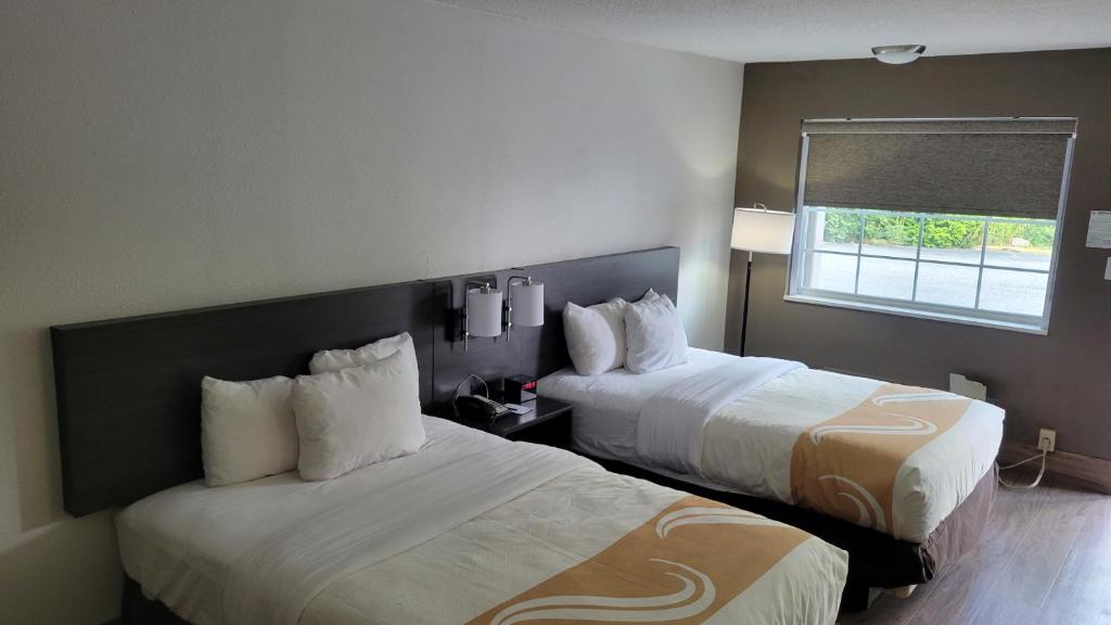 Habitación de hotel con 2 camas y ventana en Quality Inn Forsyth near GA Public Safety Training Center, en Forsyth