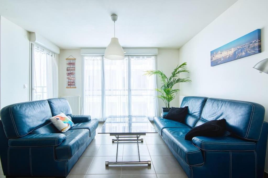 - un salon avec deux canapés bleus et une table en verre dans l'établissement Super T2 Climatisé avec Balcon à pied plage Catalan, à Marseille