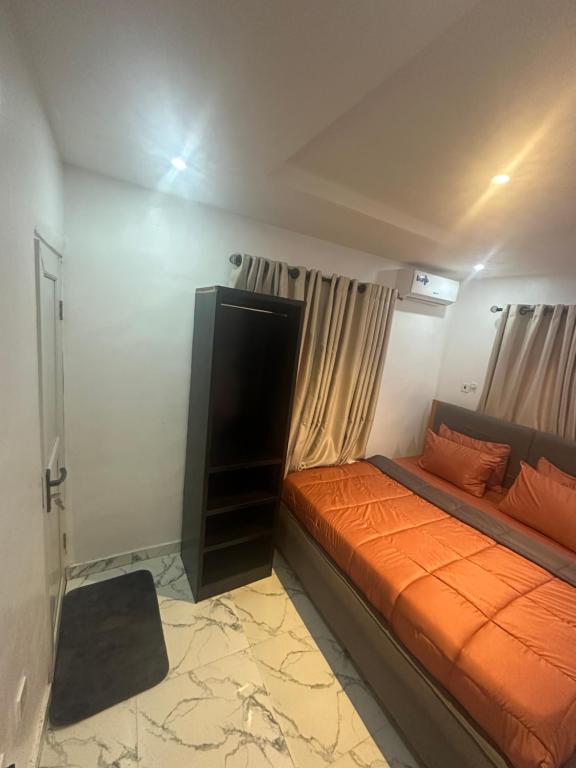 a bedroom with a bed with an orange blanket at Deemich Maison 2bed apartment. in Lagos