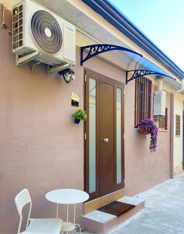 een huis met een ventilator en een tafel buiten bij Lætitia Cottage Apartment in Aversa