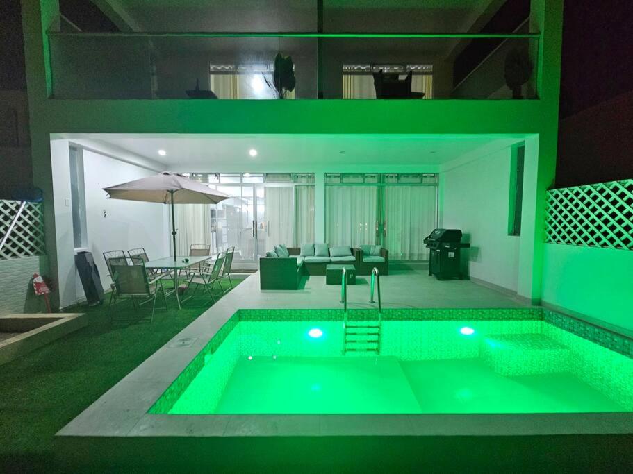 a large swimming pool with a green lighting in a house at Casa de Playa Luxury Laguna Azul Tacna in Tacna