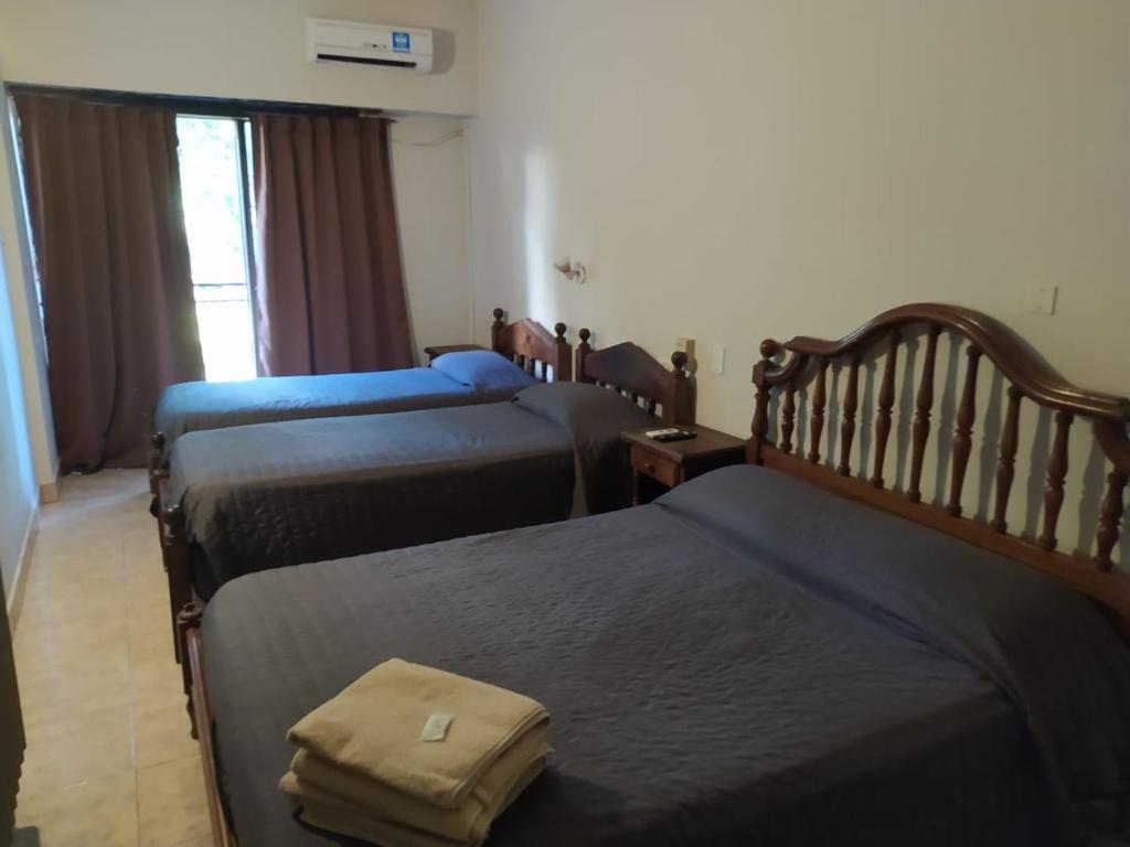 um quarto de hotel com três camas num quarto em Hotel Manzanares Plaza em Buenos Aires