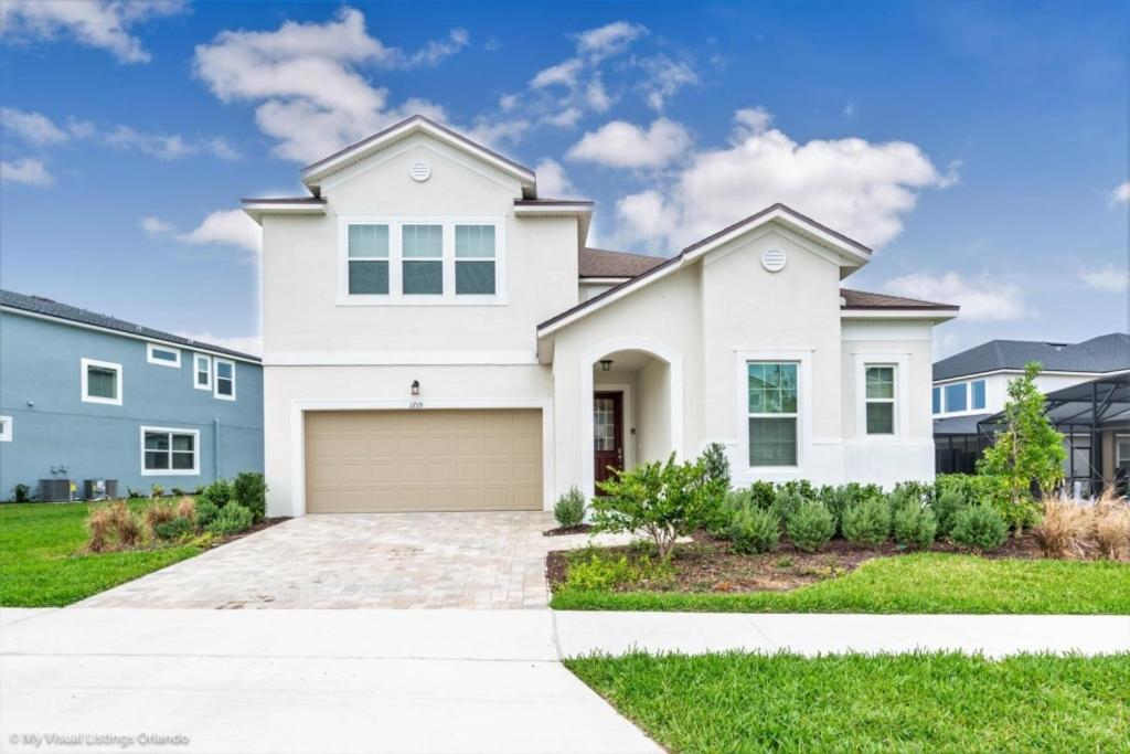 a white house with a garage at 1719CVT Orlando Newest Resort Community Town Home villa in Orlando