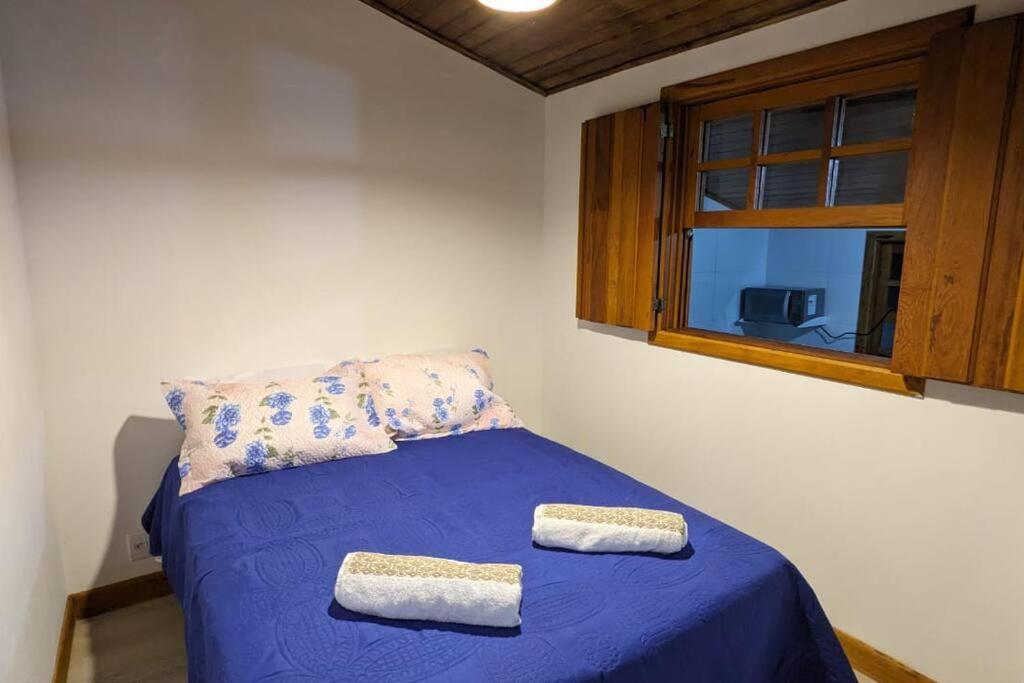 a bedroom with a blue bed with two towels on it at Casa histórica do escravo isidoro in Diamantina