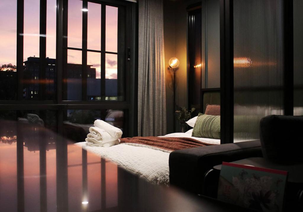 Habitación con cama y ventana grande. en The Green Rooms - Luxury themed micro apartments inspired by tiny home design, en Canberra