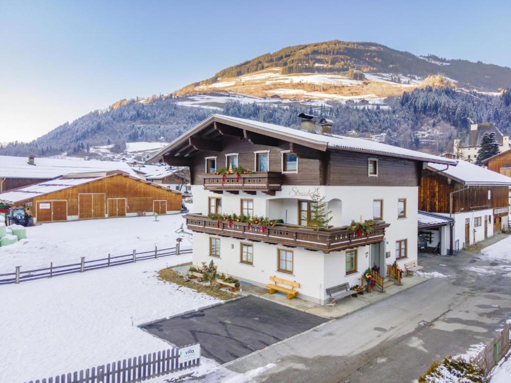 a building with a snow covered mountain in the background at Strasshof in Stuhlfelden