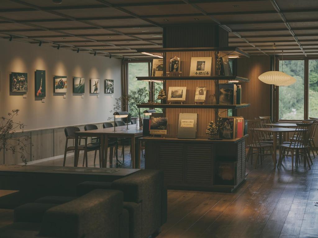 a restaurant with tables and chairs in a room at Chalet Shiga in Yamanouchi
